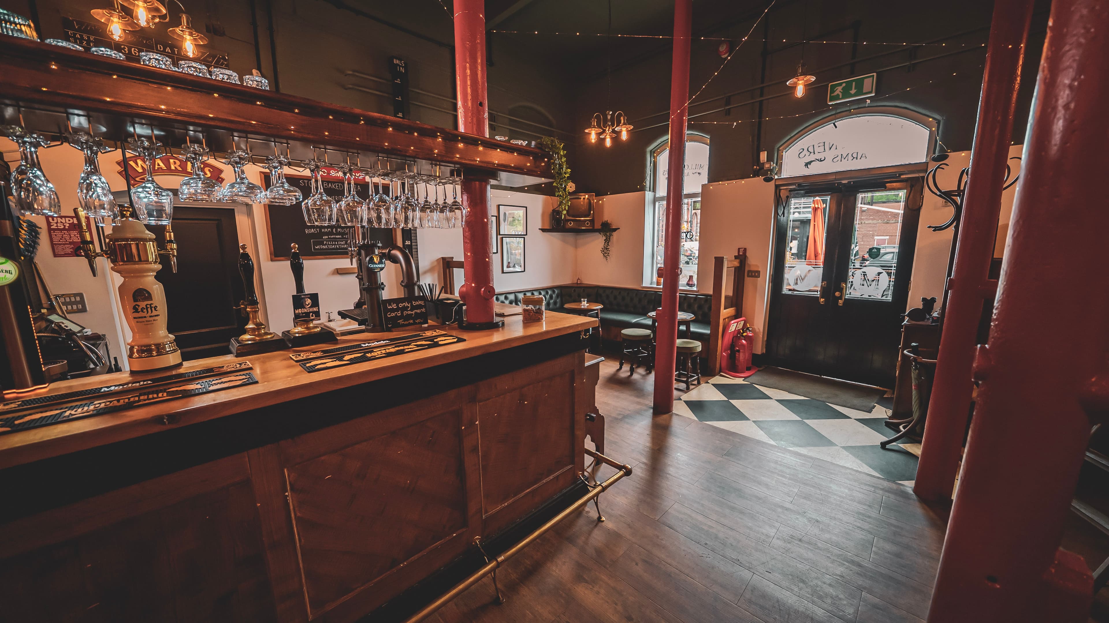 The Millowners Arms bar and seating, warmly lit for an evening event